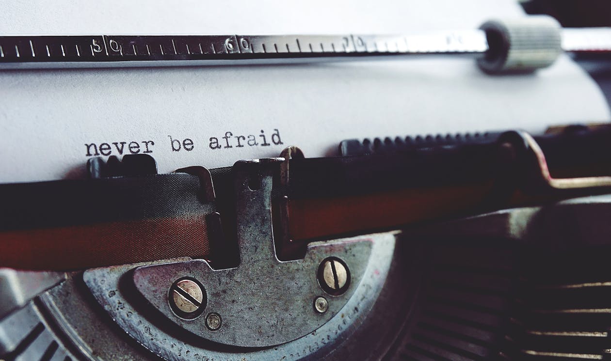 Close-up of a typewriter with the phrase "never be afraid" typed on paper. Close-up of a typewriter with the phrase "never be afraid" typed on paper.