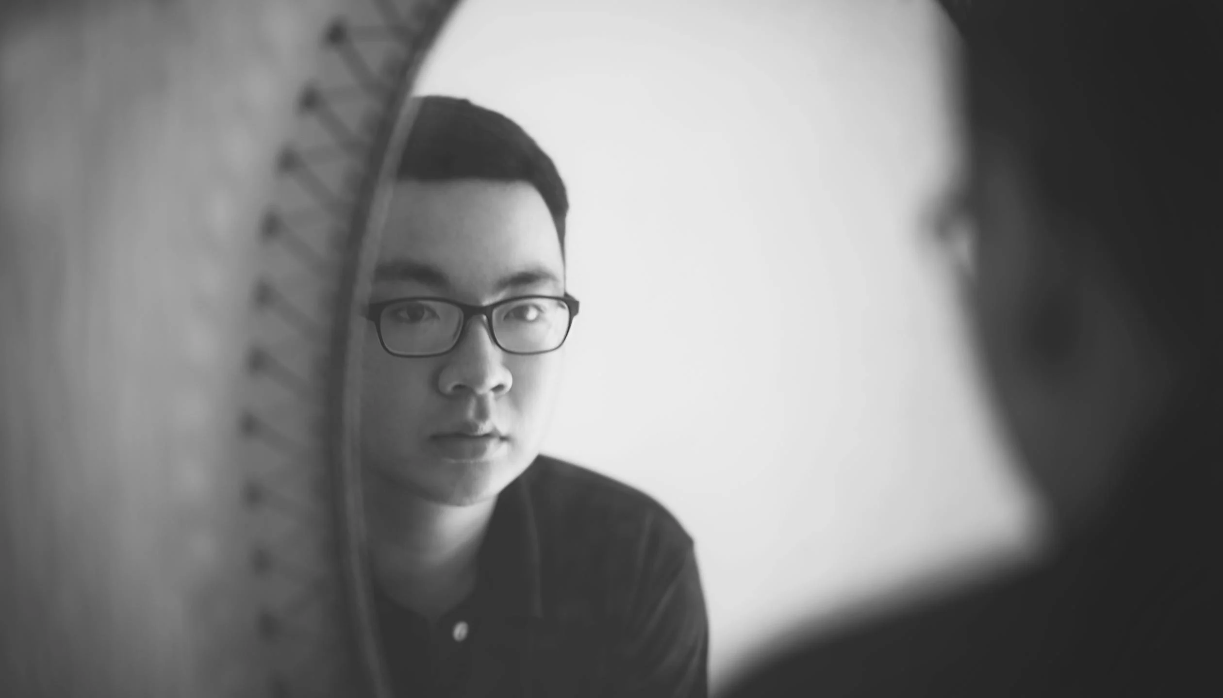 Black and white photograph showing a person with glasses looking thoughtfully in a mirror, creating a reflective, introspective mood with soft focus elements Black and white photograph showing a person with glasses looking thoughtfully in a mirror, creating a reflective, introspective mood with soft focus elements